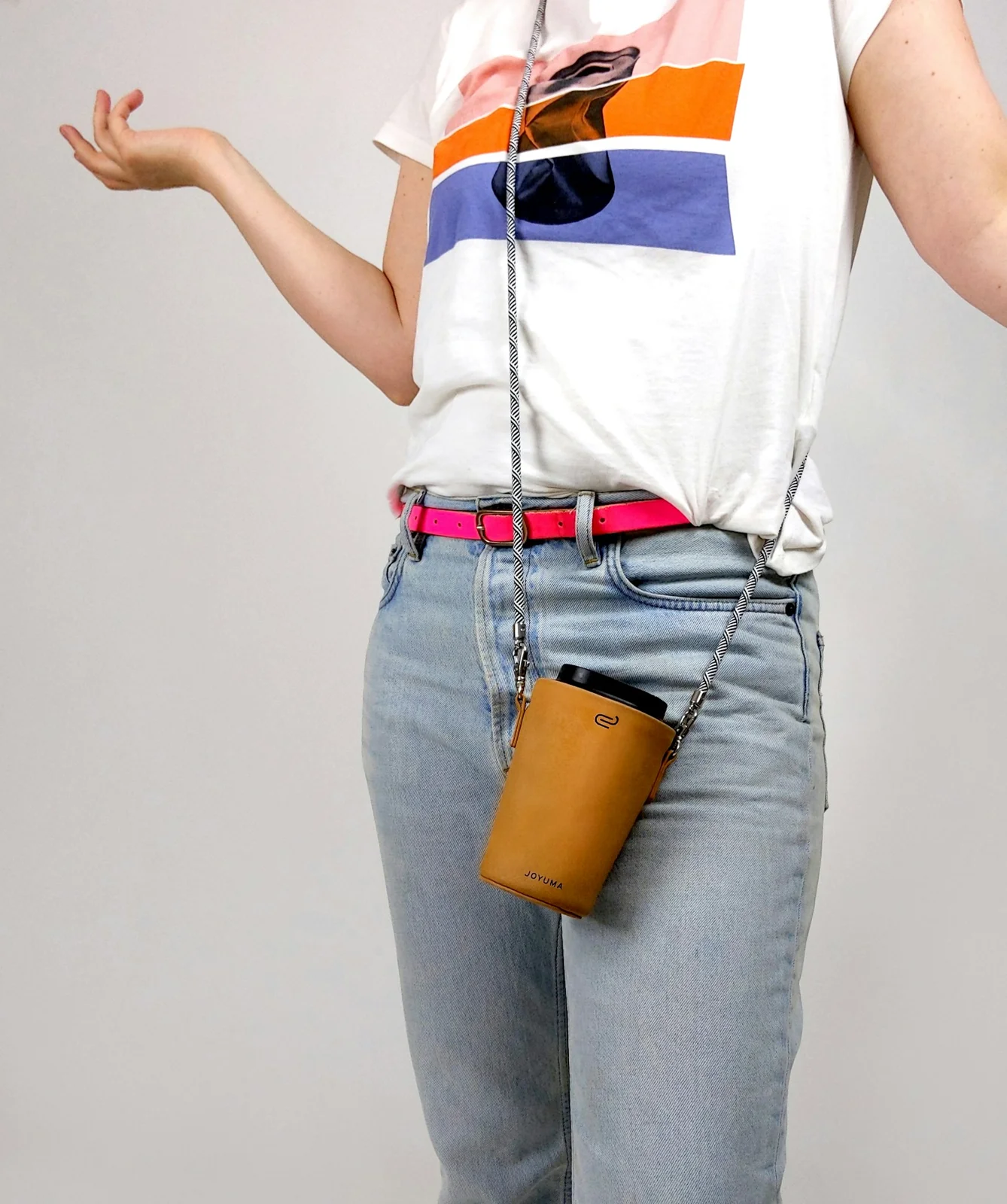 Woman wearing a white shirt and blue jeans with a coffee carrier
