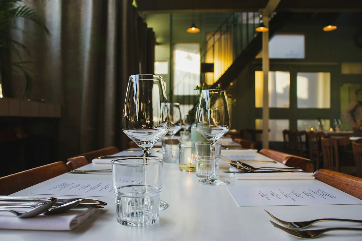 A dining table set with glasses and candles