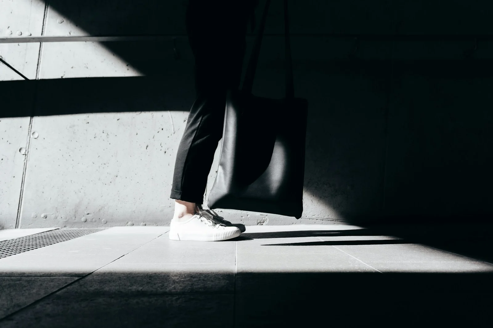 Person wearing white sneakers in a street scene